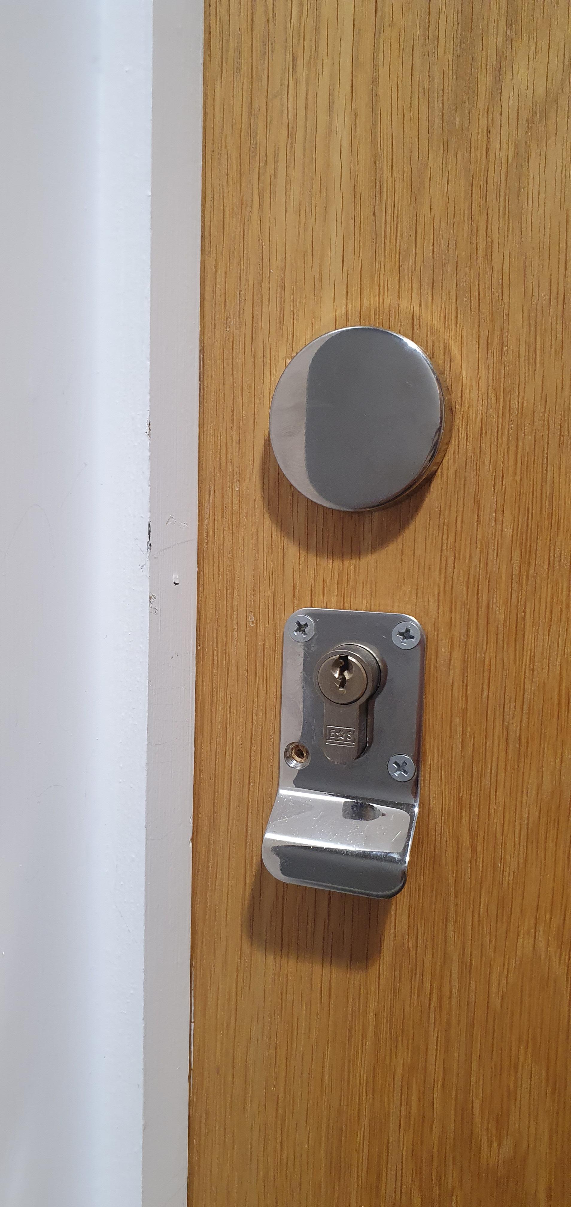 Anthony from AD Locksmithing holding open a door with a pick that has been opened when the customer was locked out and rang for an emergency locksmith