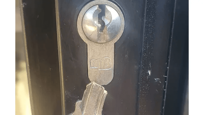 A photo of a door lock with a key stuck in the door lock in newcastle upon tyne