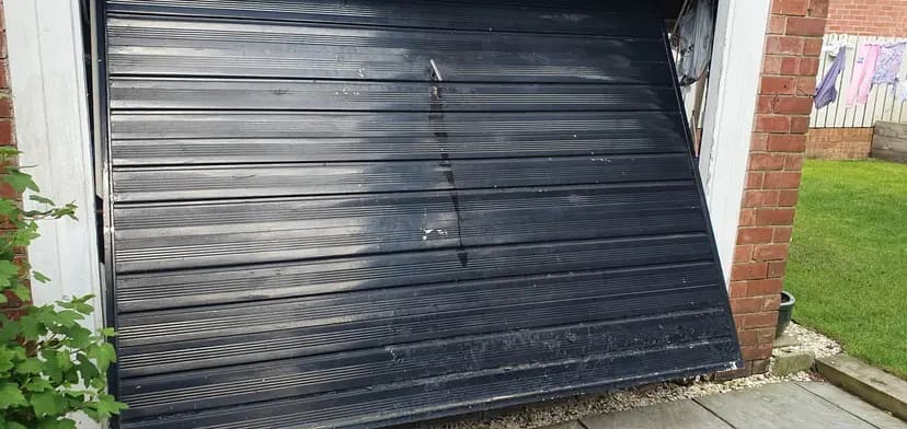 A garage door slightly ajar ready for repair