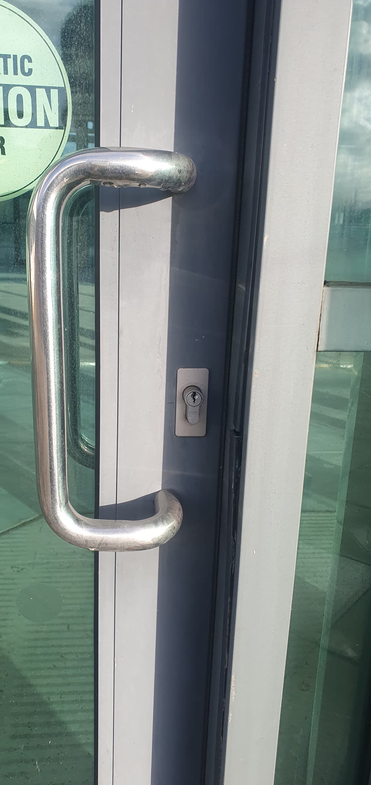 A picture of a broken door lock on a commercial building