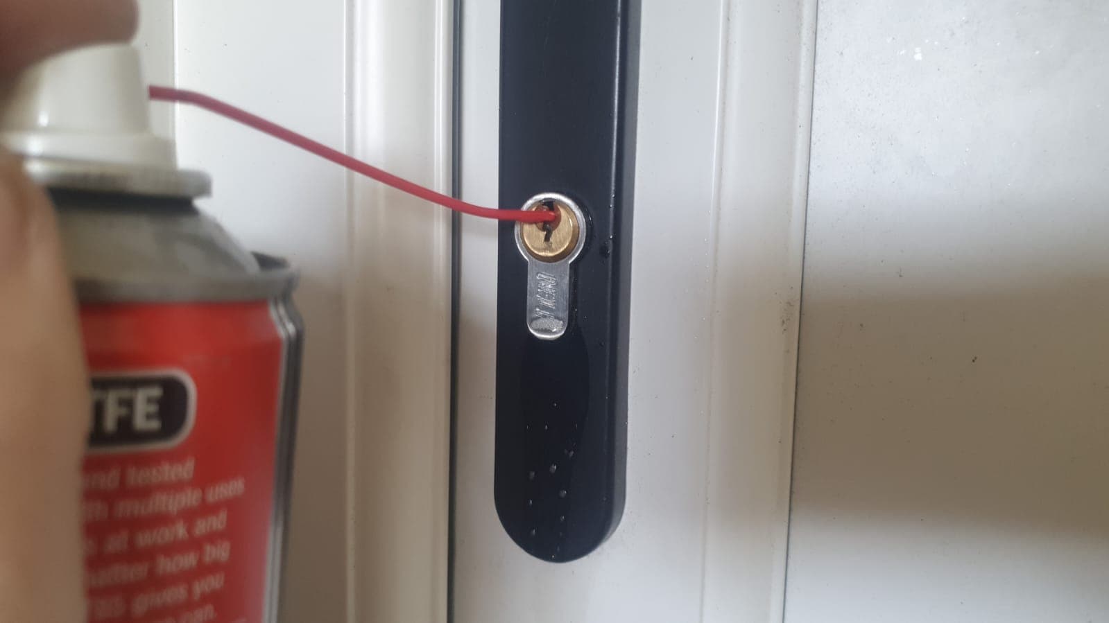 Image shown of Locksmith lubricating a lock